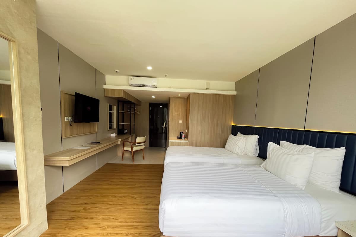 A modern hotel room with a large bed, a desk, and a chair.
