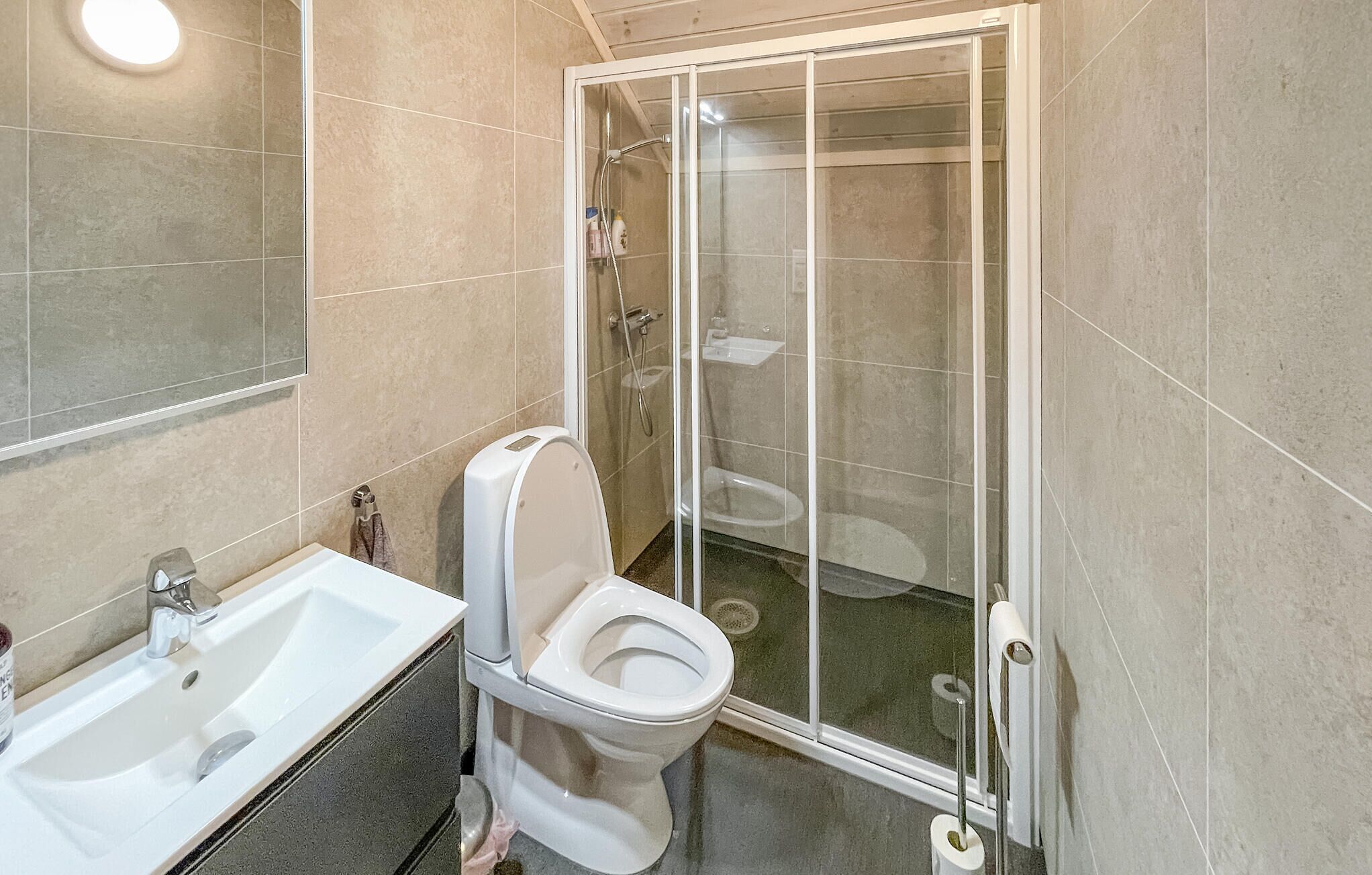 Une salle de bain avec une douche, des toilettes et un lavabo.