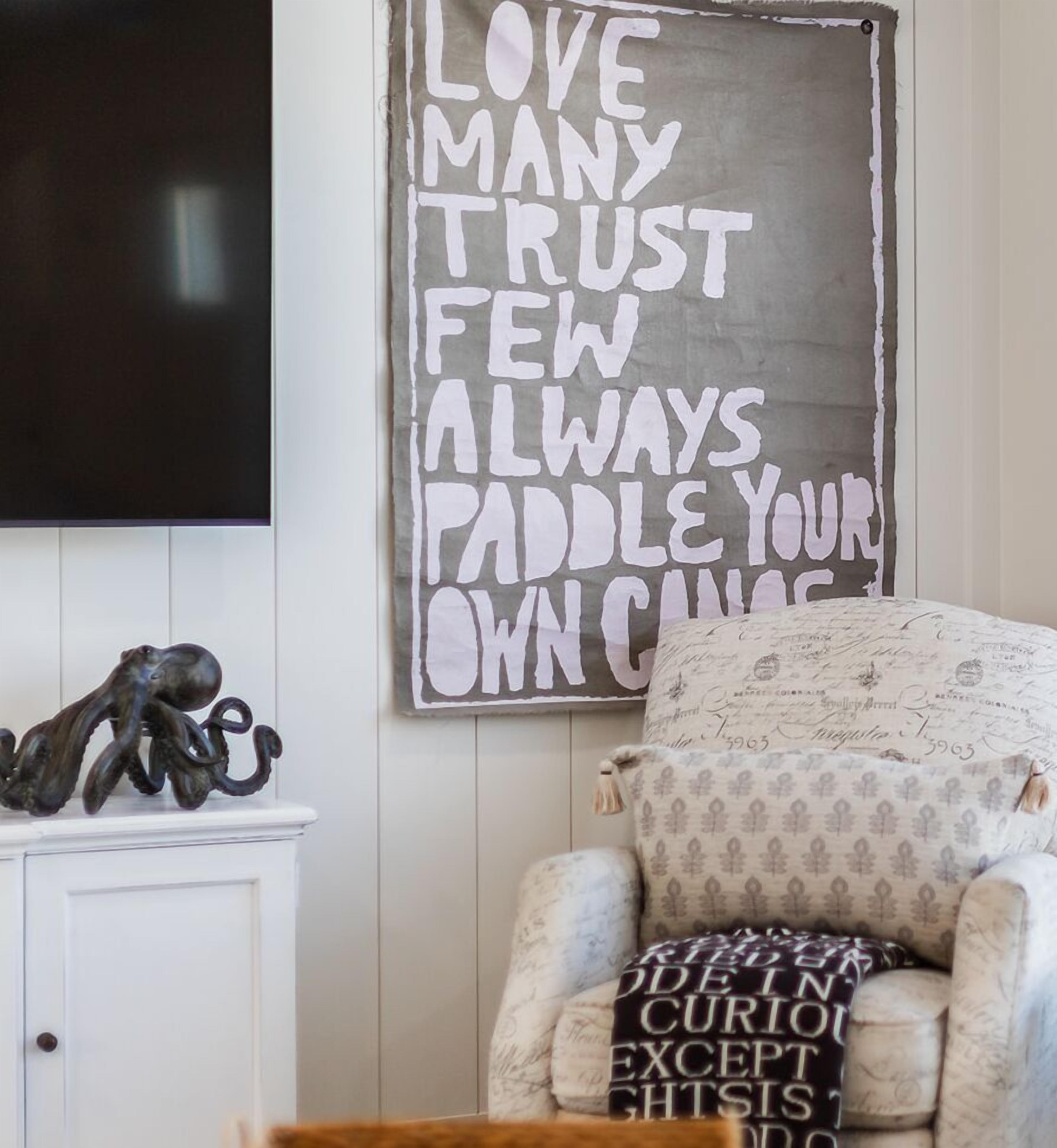 A cozy room with a motivational quote on the wall, a comfortable chair, and a decorative octopus sculpture.