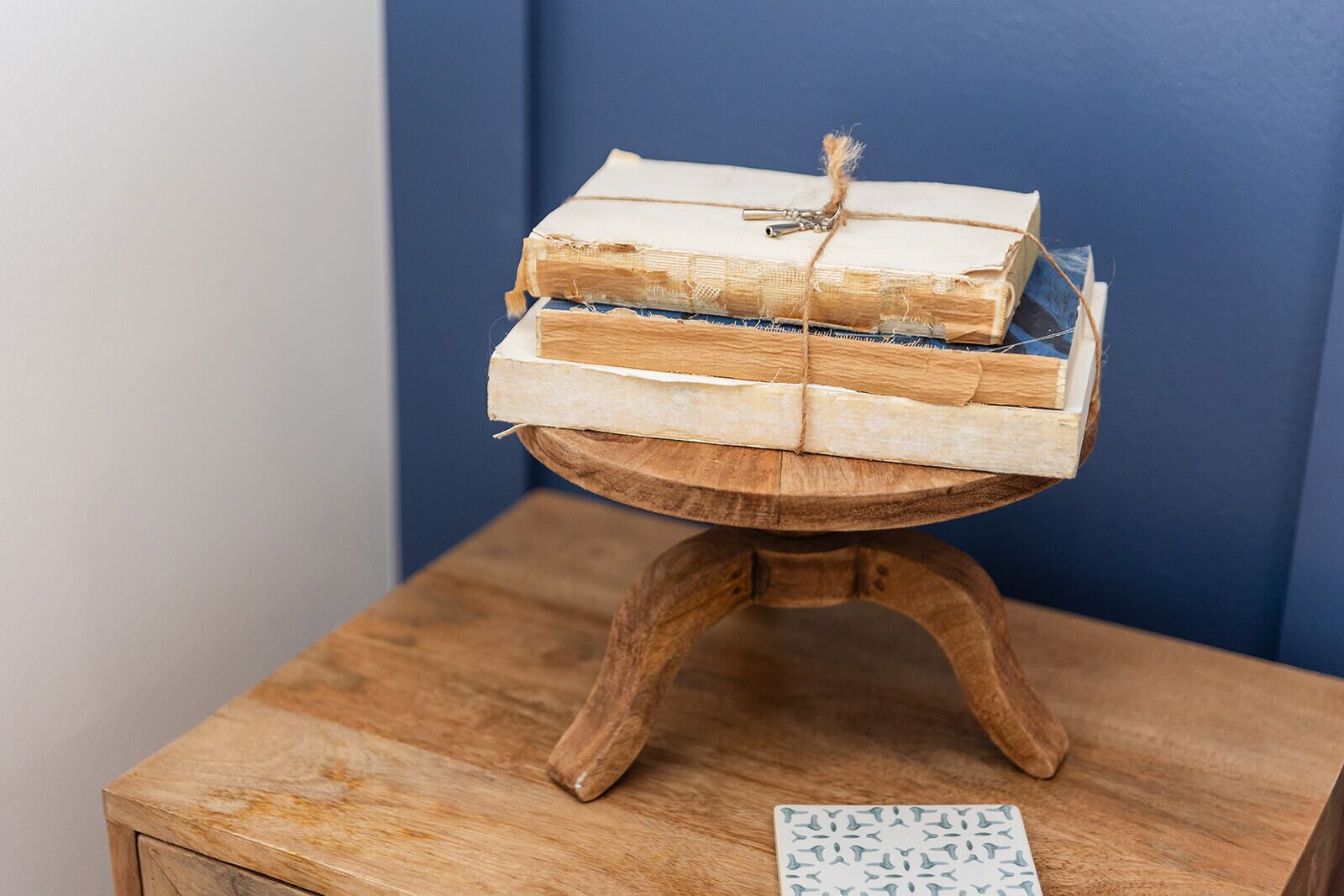 Una mesa de madera con una pila de libros atados con un cordón.