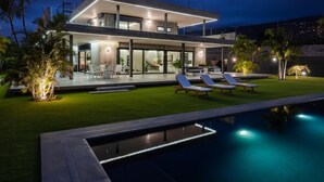 A modern two-story house with a swimming pool, outdoor seating, and a well-lit patio area. - KARAT Villa Atelier de la Vega (Playa Paraiso)