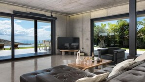 A modern living room with a large TV, leather sofa, and a wooden coffee table. - KARAT Villa Atelier de la Vega (Playa Paraiso)