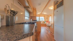 Una cocina compacta con encimera de granito, estufa y refrigerador.