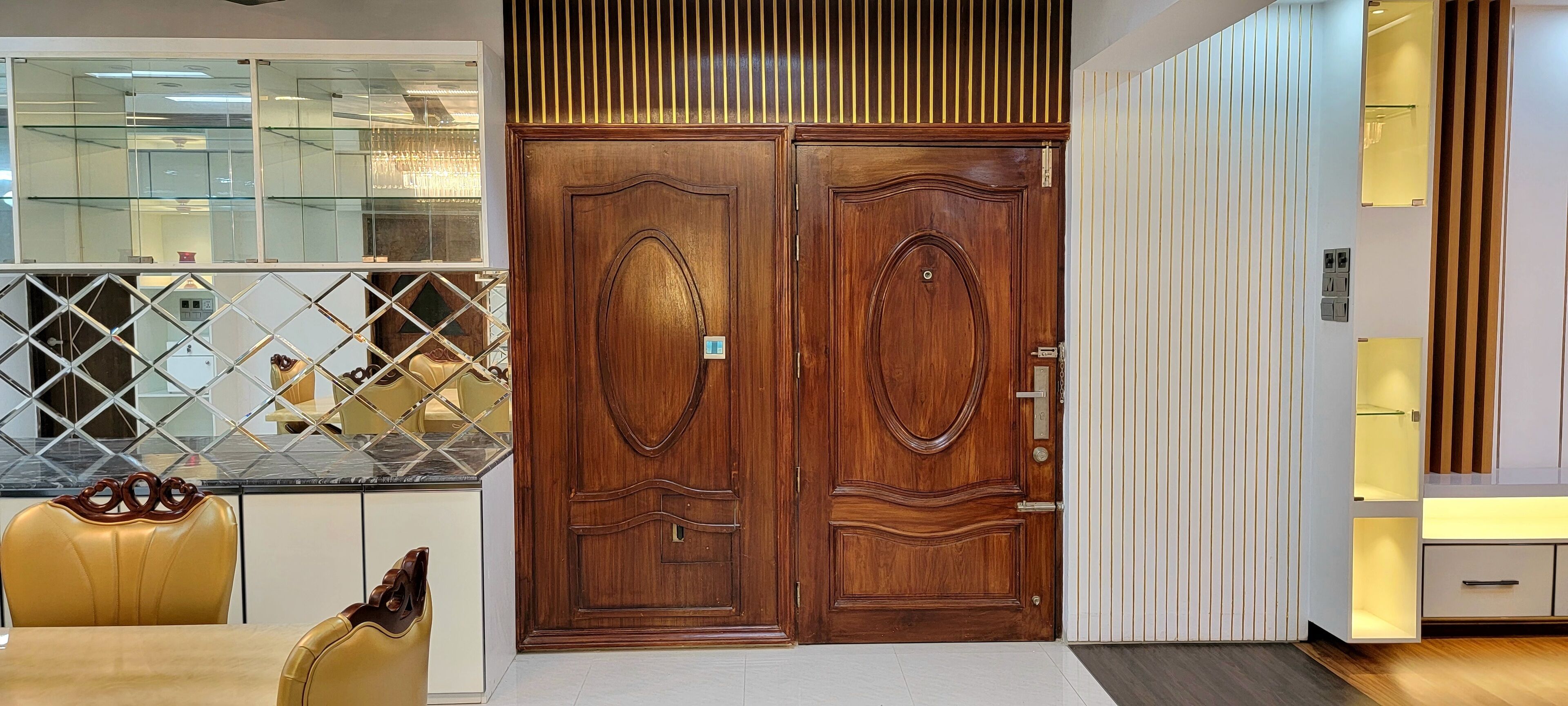 Une cuisine moderne avec une porte double en bois, un coin repas avec des chaises jaunes et un meuble vitrine en verre.