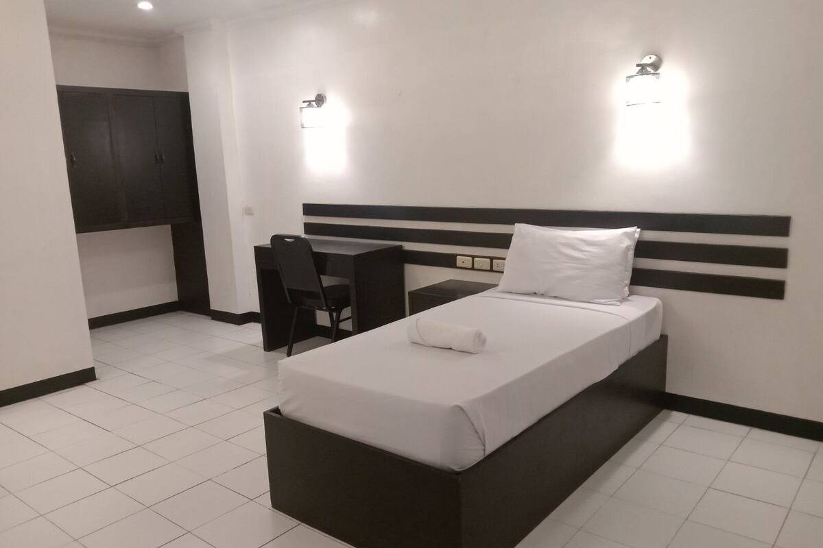 Una habitación de hotel moderna con una cama, un escritorio y una silla.
