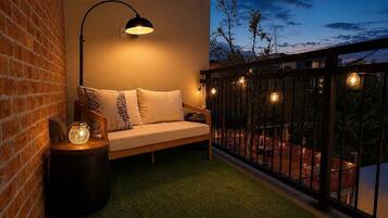 A balcony with a sofa, a lamp, and decorative lights.