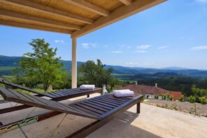 A covered outdoor seating area with two lounge chairs and a view of a valley and mountains. - Villa Lapis with private Pool, Buzet, Croatia (Buzet)