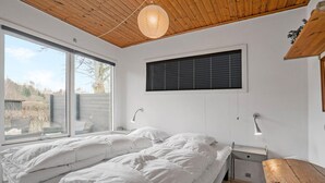 A bedroom with a large bed, a window with blinds, a bedside lamp, and a wooden ceiling. - Nice home in Børkop with Wi-Fi (Børkop)