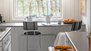 A kitchen with a window, two chairs, a table with a croissant, and a bowl of fruit. - Nice home in Børkop with Wi-Fi (Børkop)