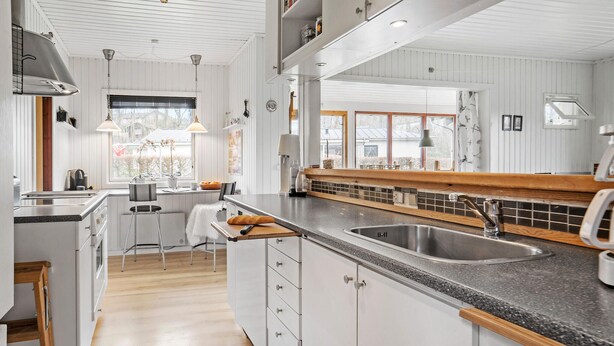 A modern kitchen with white cabinetry, a granite countertop, and a large island with a sink. - Nice home in Børkop with Wi-Fi (Børkop)