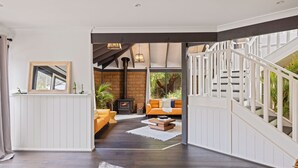 Een modern interieur met een open haard, een trap en een gezellige zithoek.