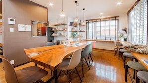 A modern dining area with a wooden table, chairs, and pendant lighting. - THE BLAUBAUM TOYA (Toyako)