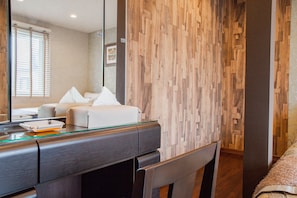 Experience comfort in this stylish room with a large mirror, a made bed, and wooden paneling.