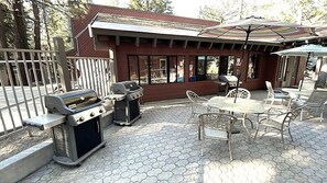 An outdoor patio with a grill, table, and chairs. - Remodeled Condo w/ View & Near Gondola 590 (Mammoth Lakes)