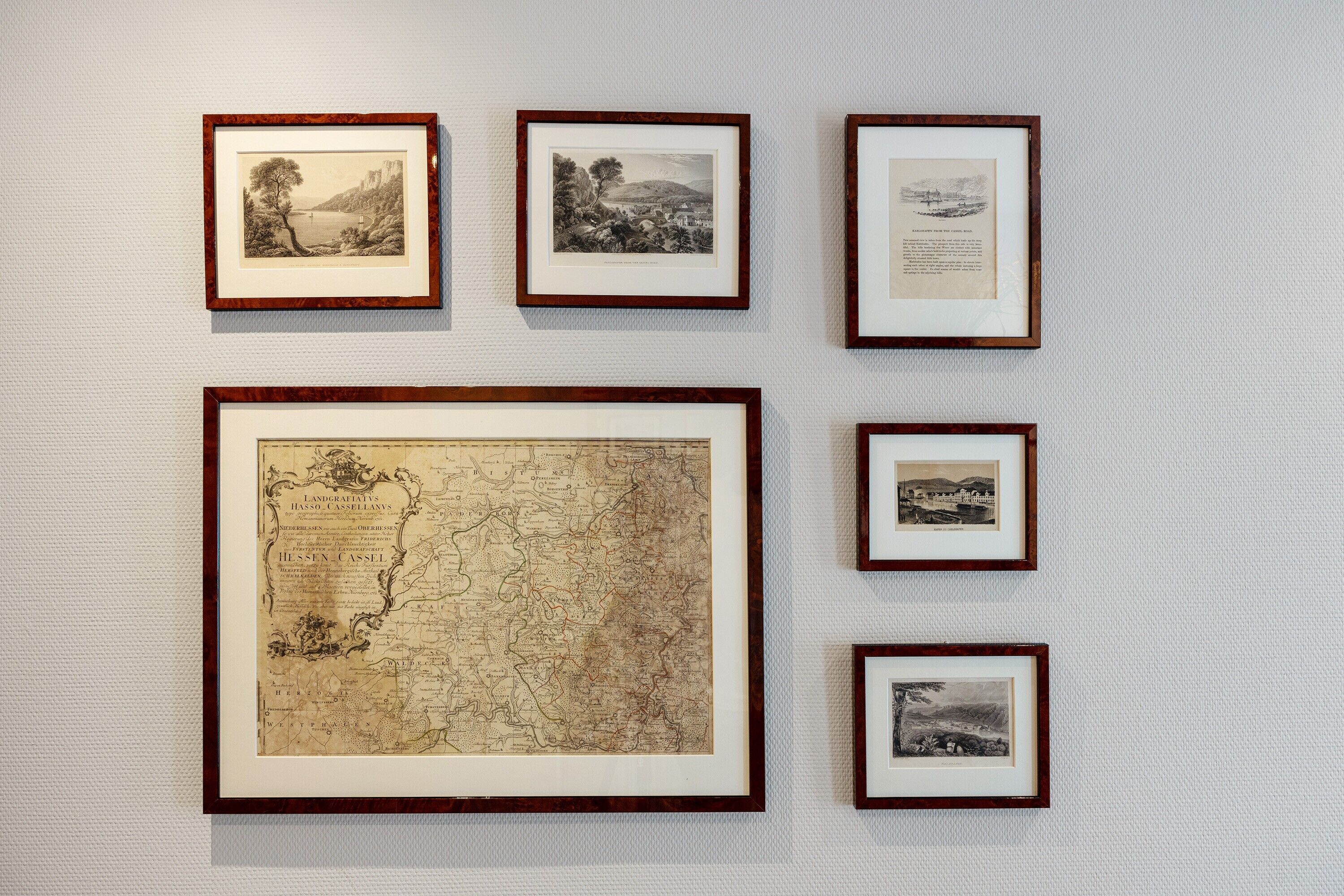 A wall with framed historical maps and documents.
