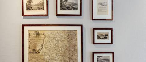 A wall with framed historical maps and documents.