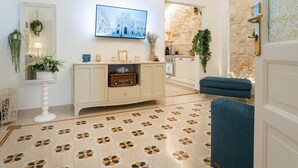 Uma sala de estar moderna com lareira, televisão na parede e piso estampado.