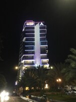 A multi-story hotel with a prominent vertical light strip and a large illuminated 'A' logo.