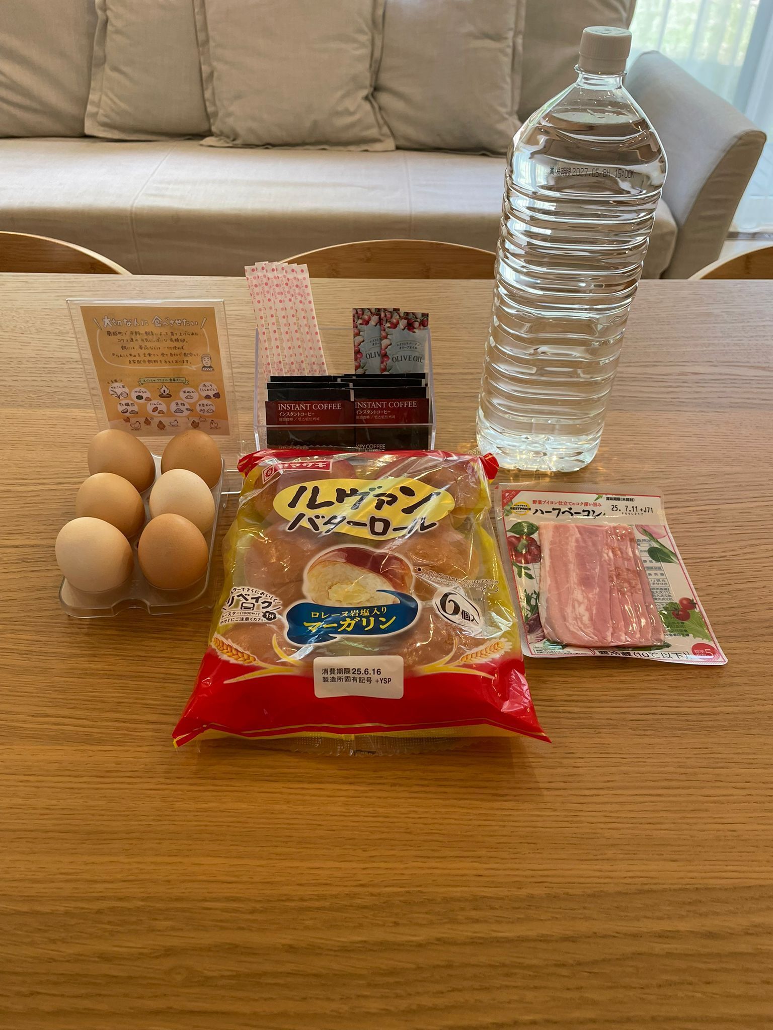 Una mesa con alimentos, café instantáneo, una botella de agua y un menú.
