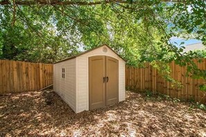 Situated in a garden, this cozy shed offers a simple, functional space.