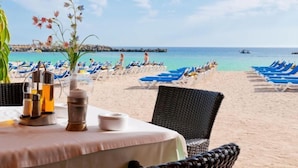 A beachside dining area with a table set for two, overlooking the sea. - Villa Tauro 2 by Interhome (Mogan)