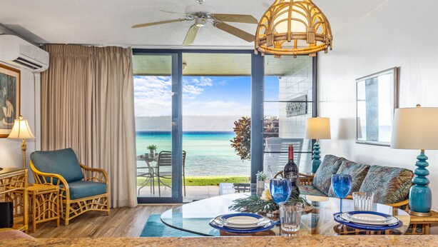 A hotel room with a dining area, a ceiling fan, a view of the ocean, and a balcony with a table and chairs. - Whale Watching from your lanai, unbeatable views (Lahaina)
