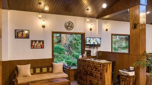 Un interior de madera con un sofá, una recepción y obras de arte en la pared.