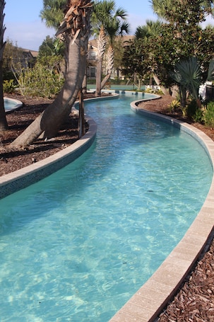 Una piscina al aire libre, sombrillas, sillones reclinables de piscina