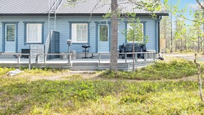 A blue house with a porch, a table, and chairs.