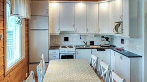A compact kitchen with white cabinets, a stove, and a microwave.