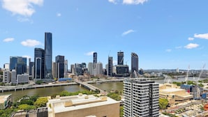Un paisaje urbano con rascacielos modernos, un río y un puente.