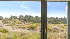 A view from a window overlooking a grassy hillside with trees and a clear sky. - "Ehawee" - 350m from the sea by Interhome (Saltum)