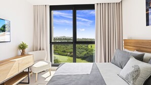 Un dormitorio moderno con un gran ventanal, una cama, una mesita de noche, una silla y vistas a un paisaje.