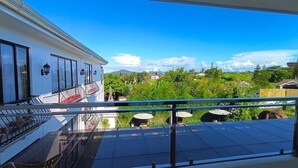Un balcon donnant sur un quartier résidentiel, avec vue sur les maisons et la végétation.