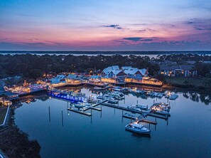 Un port de plaisance où des bateaux sont amarrés aux quais, entouré de bâtiments offrant une vue sur le front de mer.