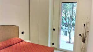 A bedroom with a bed, a wardrobe, and a view of the outside. - Stunning Villa-beahost (Lignano Sabbiadoro)