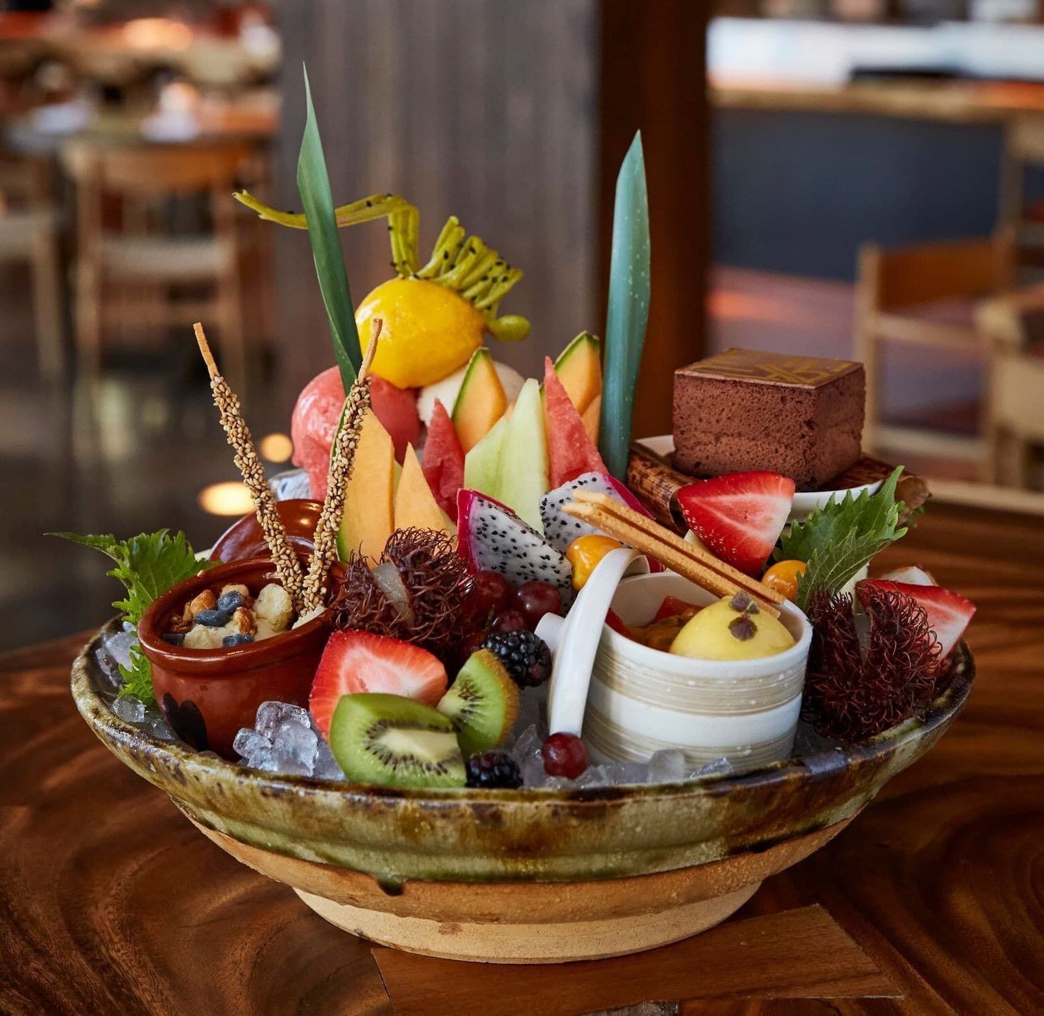 A fruit and dessert platter on a wooden table.