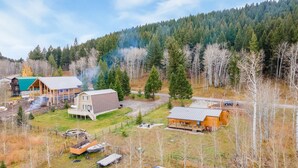 Une propriété rurale comprenant une grande grange, un chalet et un quai pour bateaux.