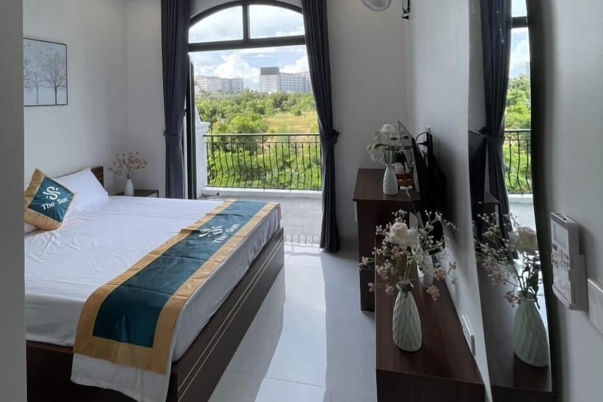 Ein modernes Hotelzimmer mit einem großen Bett, einem Balkon mit Blick auf die Stadt und einem Spiegel an der Wand.