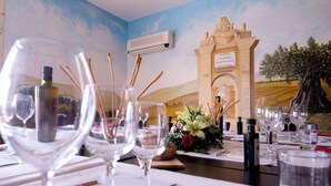 A dining table set with wine glasses, bottles, and a centerpiece of flowers. - Room-camagna Country House Scopello Room (Partanna)