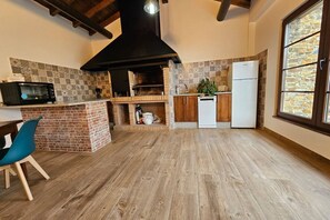 A kitchen with a brick island, a microwave, a stove, and a refrigerator.