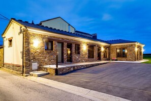 A stone building with a covered patio and a driveway.