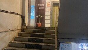 Eine Treppe führt zu einer Tür, an der ein Schild für die Brain & Heart Care Clinic angebracht ist.
