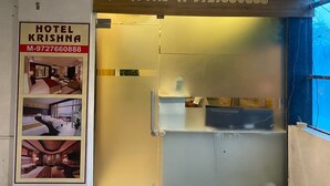 Ein Hotelschild mit dem Namen 'Hotel Krishna' und einer Kontaktnummer.