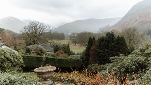 A mountainous landscape with a valley, houses, and a variety of trees. - Grey Walls (Penrith)