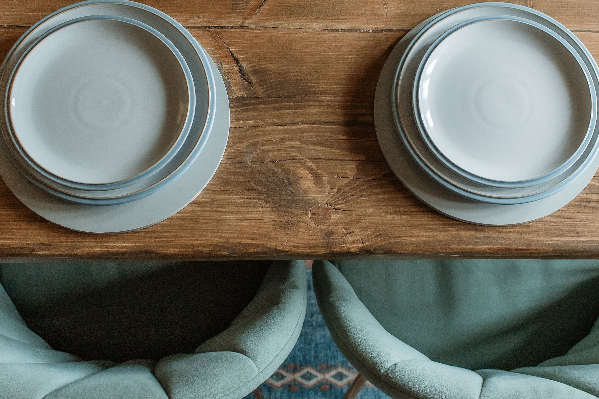 Dos platos blancos con detalles azules sobre una mesa de madera.