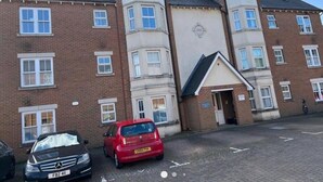 A multi-story residential building with a brick facade, multiple windows, and a small entrance with a door. - Central Location 2-bed Apartment in Maidstone (Maidstone)