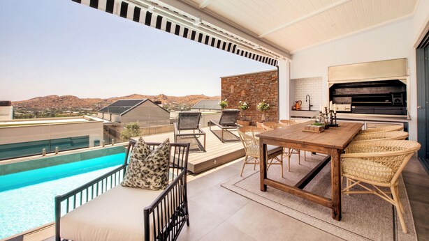 A rooftop patio with a pool, outdoor seating, and a kitchen area. - The Weinberg Urban Pods (Windhoek)