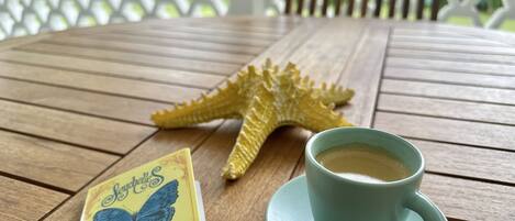 A wooden table with a starfish, a cup of coffee, and a book titled "Sophie".