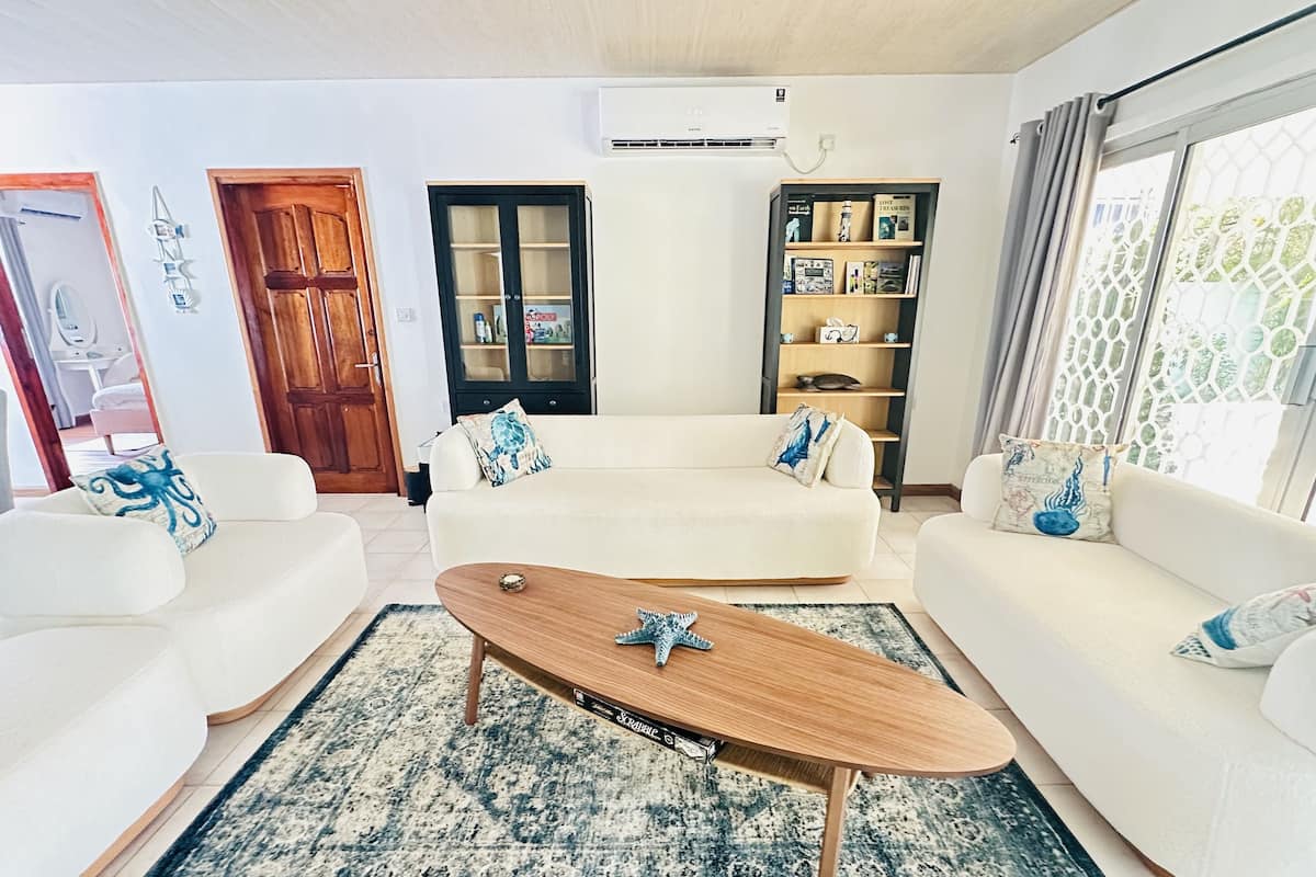 Un salon comprenant un canapé, une table basse, une bibliothèque et une porte.